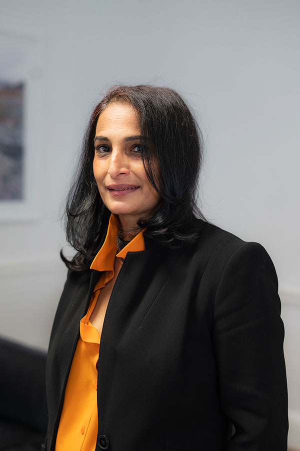 Woman standing wearing orange and black business attire
